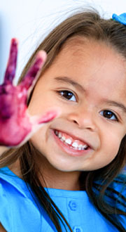 A mother and child laugh together in a preschool setting