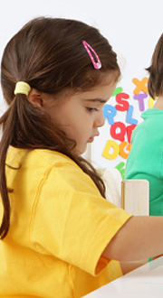 A young Latina girl concentrates on painting